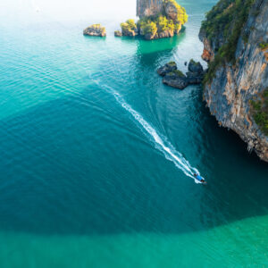 Sea views and rocky islands with a long tail boat.