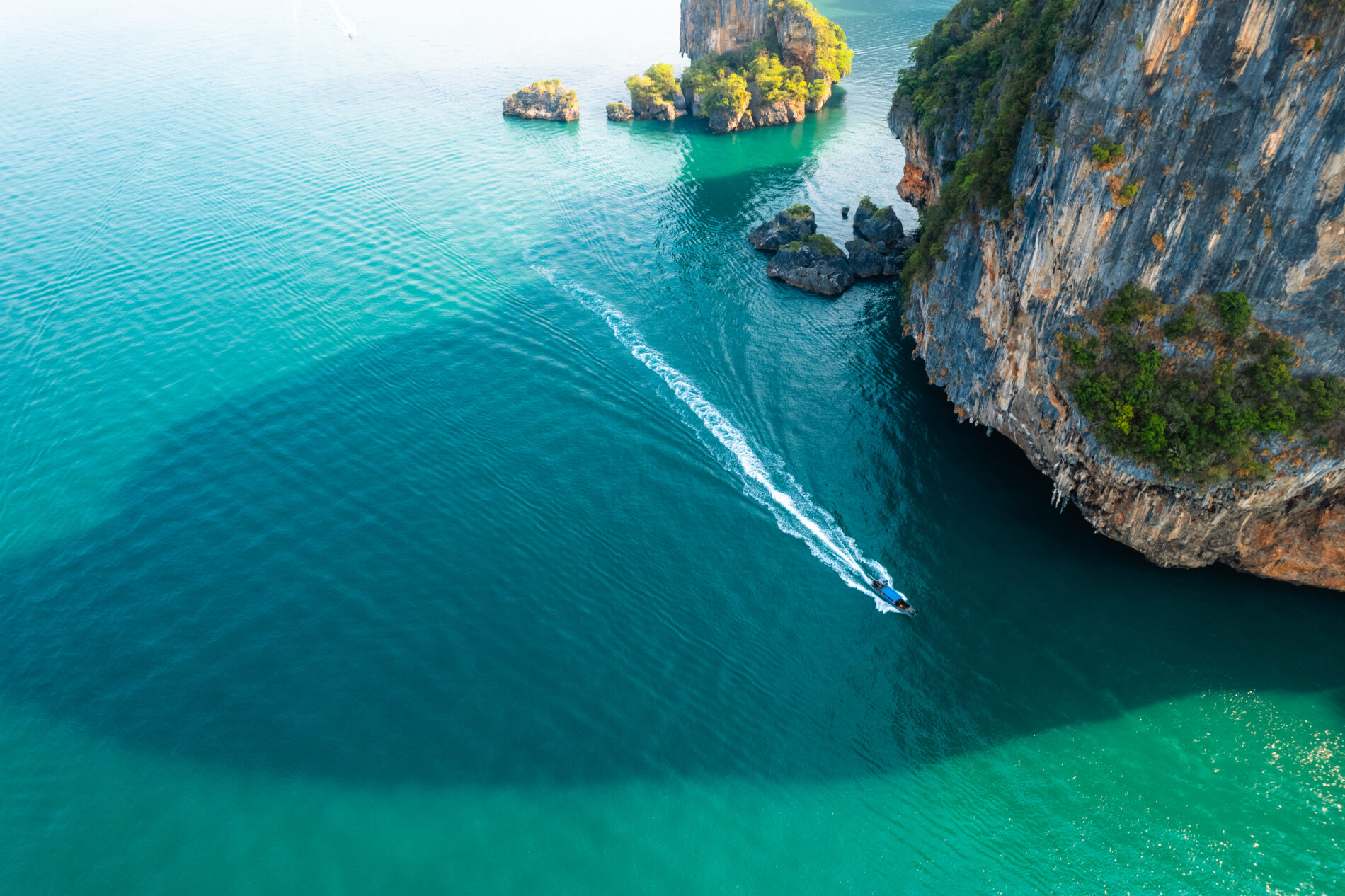 Sea views and rocky islands with a long tail boat.