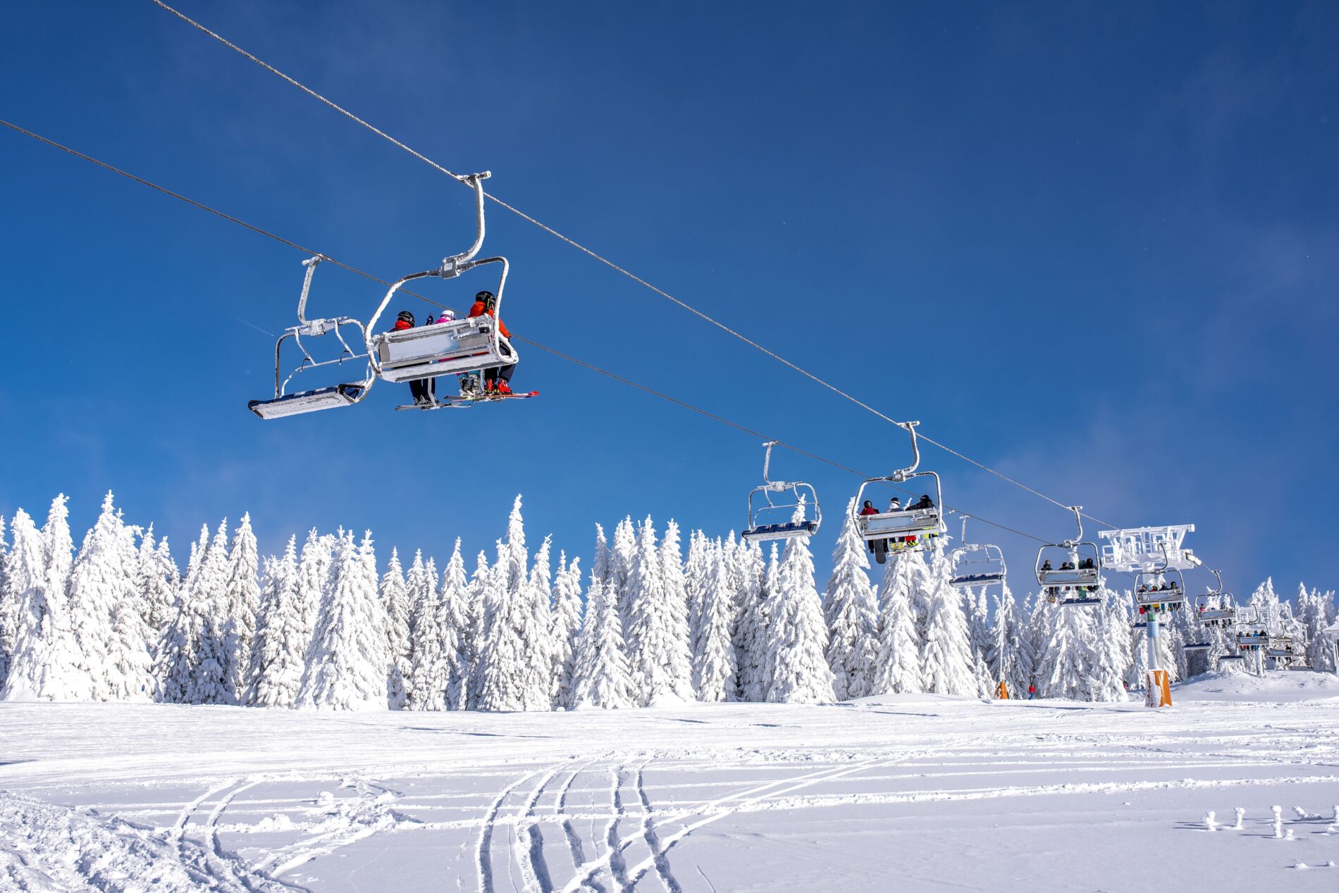 skiers ski lift mountain resort with sky mountains