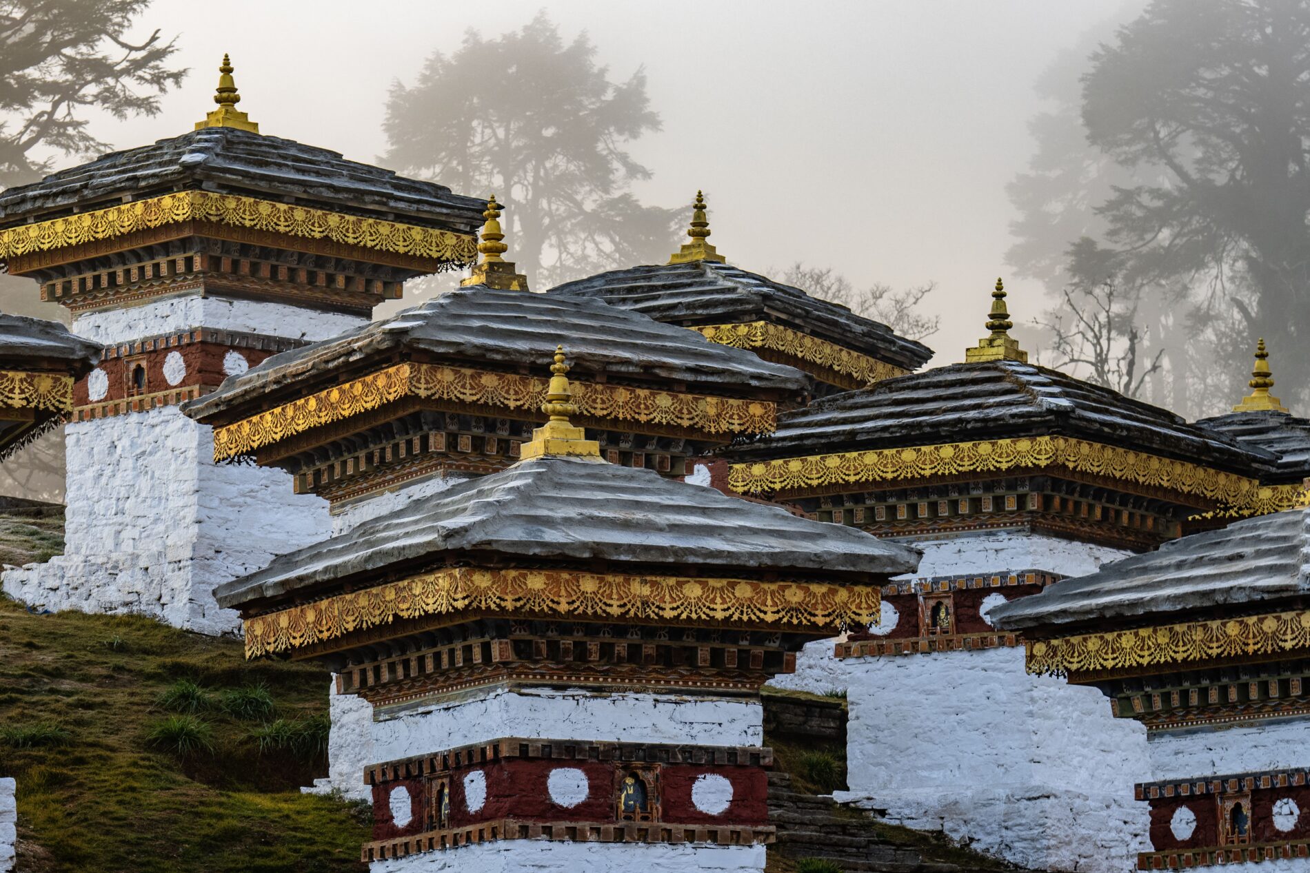 Sunrise through fog at the Dochula Pass Tibetan Buddhist Stupas Chorten in the Himalayas of Bhutan