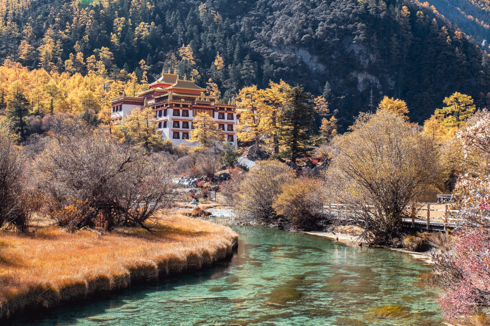Chong Gu temple on autumn hill with emerald river at Yading